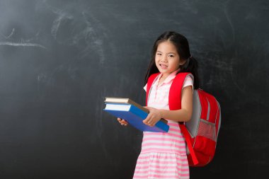 sevimli küçük kız öğrenci ağır ders kitabı holding