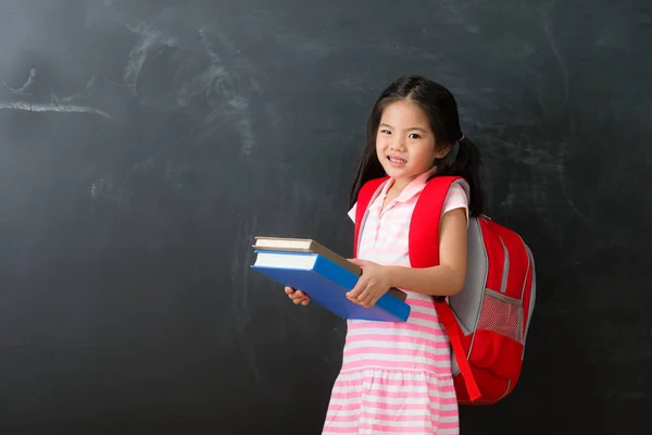 Χαριτωμένο μικρό κορίτσι φοιτητής κρατώντας βαρύ βιβλίο — Φωτογραφία Αρχείου