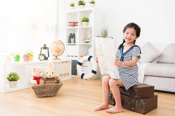 Sonriente pequeña marinera sosteniendo mapa de viaje — Foto de Stock