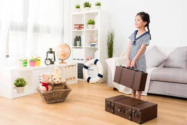 Smiling female kid sailor carrying retro suitcase — Stock Photo, Image