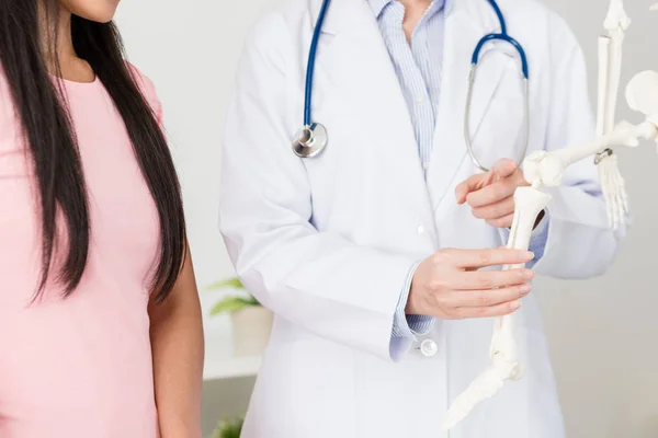 Médico do hospital feminino usando modelo de esqueleto — Fotografia de Stock