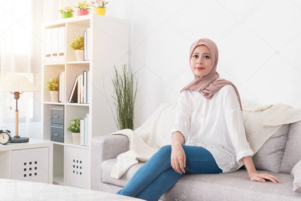 pretty elegant muslim woman sitting on sofa couch