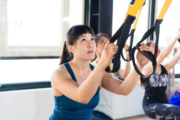 Profissional de ensino treinador asiático usando TRX — Fotografia de Stock