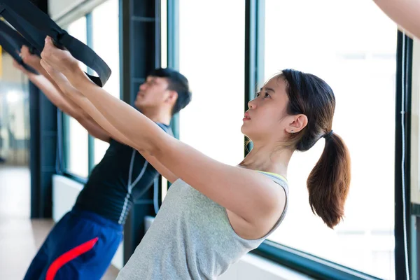 Asian girl using her muscle to pull up — Stock Photo, Image