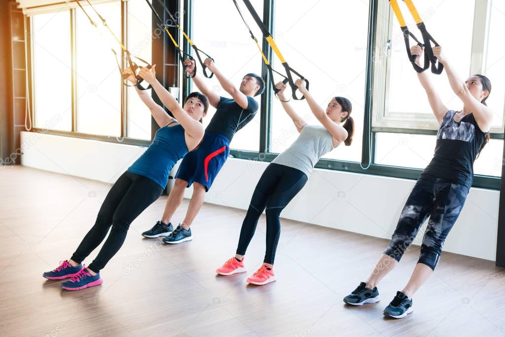 team of Asian people training with TRX