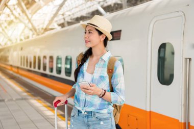 Bir cep telefonu tutan Asya seyahat kadın