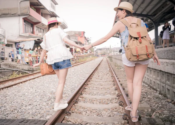 Mulheres de mãos dadas e caminhando ao longo da ferrovia — Fotografia de Stock