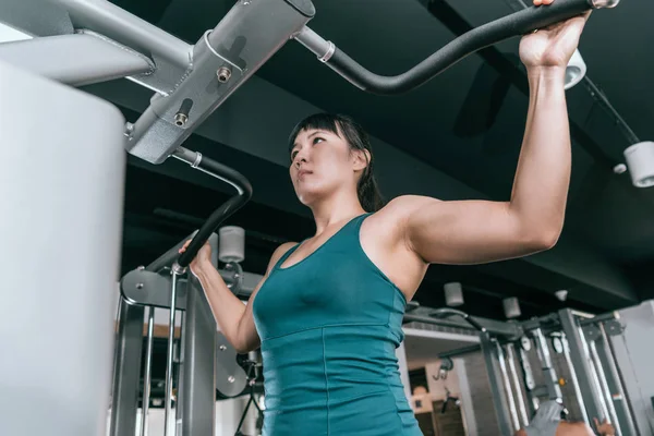 在健身房的机器上做俯卧撑的女人 — 图库照片