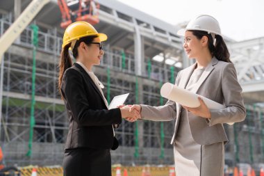 Kadın mimar gülümseme ile tokalaşırken.