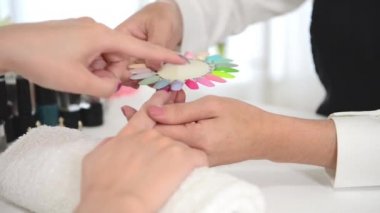 Asyalı Çinli kadın seçer manikür rengi shellac oje üstten görünüm. Tırnak teknisyeni tırnak Hizmetleri renk paletinin güzellik salonunda gösterir..