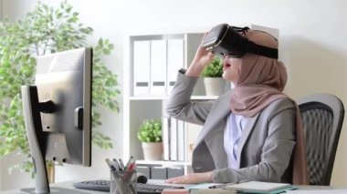 güzel genç bayan Müslüman işçi 3D video sanal gerçeklik cihaz üzerinden rahatlatıcı izlerken.