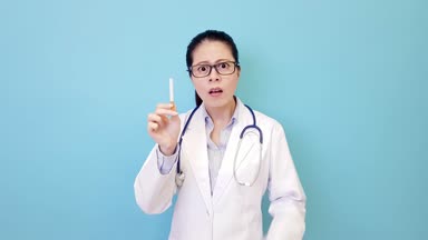 güzel genç kadın hastane doktoru reddetti sigara ve gösteren sigarayı kavramı mavi duvar arka plan üzerinde izole fırlatıp.