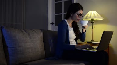 güzel iş kadını gece oda rahatlatıcı ofiste çok ve enerji artırmak için sıcak espresso kahve içme ve kendini rahat kanepede yenileyin.