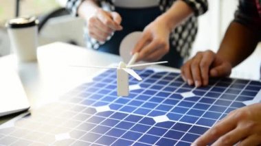 güzel kadın alternatif enerji mühendisi bir yel değirmeni güç örnek tutun ve ofis olarak gelecek güç için erkek meslektaşı ekibi ile konuşurken yakın çekim