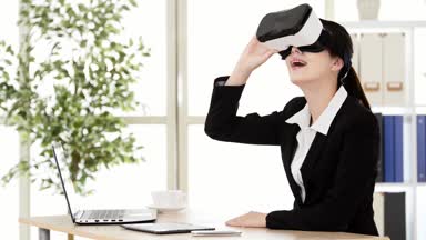 Çinli Asyalı kız ofis çalışanı ekran boyutlu etkisi modern ofis Studio masada ise şok edici nedeniyle 3d görsel Vr aygıt tarafından şaşırır.