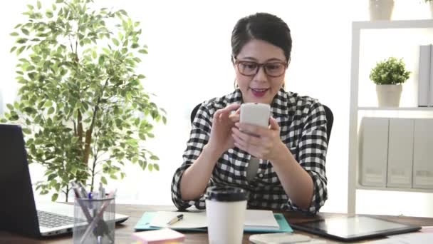 幸せなゆったりとしたビジネス女性作業と職場自宅の上に座って終了リラックス オンライン情報を閲覧するモバイルの携帯電話を使用してください — ストック動画