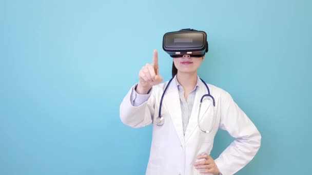 美丽漂亮的医院医生妇女穿着 技术站在蓝色背景下 观看3D 模拟视频触摸屏 — 图库视频影像