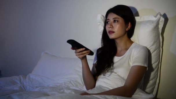 年轻的女孩坐在床上看恐怖片恐怖来湾电视上的她眼睛混合种族亚洲中国模式 — 图库视频影像