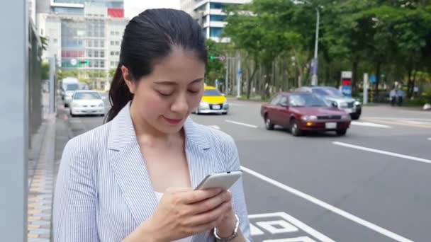 モバイル スマート フォン アプリのテキスト メッセージを使用して 道路の通り 車の横に立っている若いアジアの実業家維持渡し — ストック動画