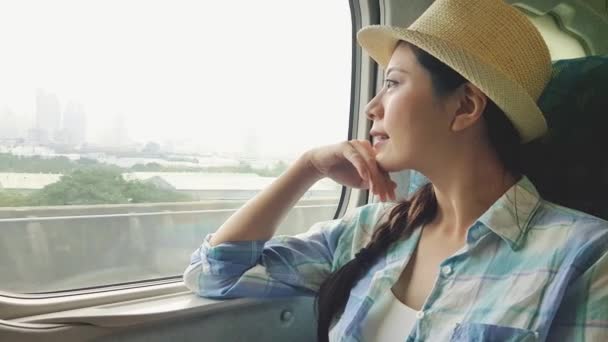 美丽的亚洲女人旅行者 从火车窗外考虑户外景观 乘坐公交车或火车去度假的年轻女士 — 图库视频影像