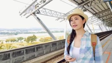 Hedef araç el bagajı ile bırakarak gelen tren istasyonunda Asyalı kadın çok güzel. Mutlu güzel kız gidip tatil için şehir içinde.
