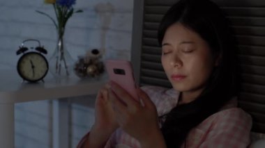 Asya modern iş kadın hala yatmadan önce çalışıyor. O yorgun hisseder ve ekşi gözleri var ama o akıllı telefonlar kullanarak işini bitirmeliyiz. Neredeyse uykuya dalar.