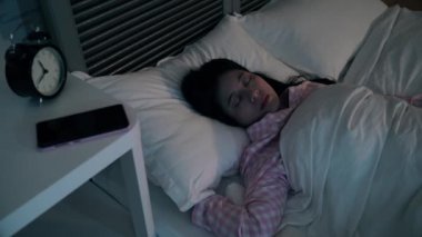 Modern genç kız gece yorgun hissetmiyorum. O döndü ve çevresinde atmış. Son olarak, uyan ve cellphone tarafından bazı video oyunları oynamak karar.