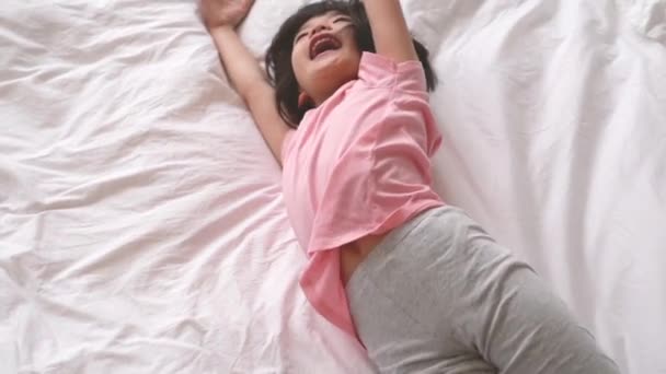 Linda Adorable Niña Pequeña Hembra Estirando Brazo Rodando Cama Llevando — Vídeos de Stock