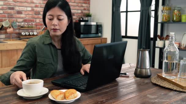 Mujer Desayunando Cocina Ella Está Usando Portátil Mismo Tiempo — Vídeos de Stock