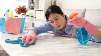 Tablo dikkatle evde oturma odasında temizlik ev kadını kadeh kaydırmak. Kadın temizlik sonuçtan memnun