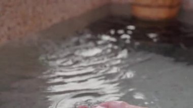 Genç kız kefalet kepçe kaplıcalar su yandan arka plan üzerinde yüzen ahşap varil sırasında. Asya Kış etkinliği.