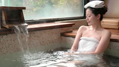 Japon kız bir dinlenme ve yerine bir havlu başında kışın sıcak springs zevk alır.