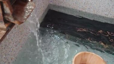ağır çekim bir Japonya doğal mineral sıcak bahar akışı sıcak buhar ve ahşap varil ile görünümünü yukarıda vefat.