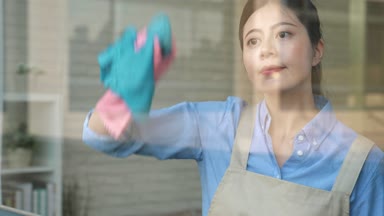 Pan çekim hizmeti çalışan kadın taşıyan bez dikkatle silerek pencerenin deterjan ile kendine güvenen genç Asya temizlik