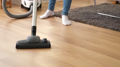 Dolly atış kadınların evde oturma odasında yere temiz yılın sonlarında temizlik elektrik süpürgesi kullanın. Ev kavramı.