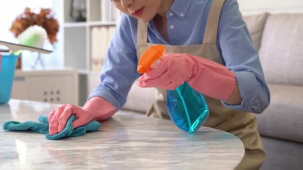 家庭主妇的倾斜拍摄每年清洁喷洒洗涤剂和努力擦拭在家里的客厅表 — 图库视频影像
