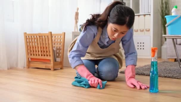 女性主婦のドリー ショットは春の大掃除中に 自宅でクリーニング後のリビング ルーム 木製の床の上に座って疲れを感じるまたは毎年きれい — ストック動画