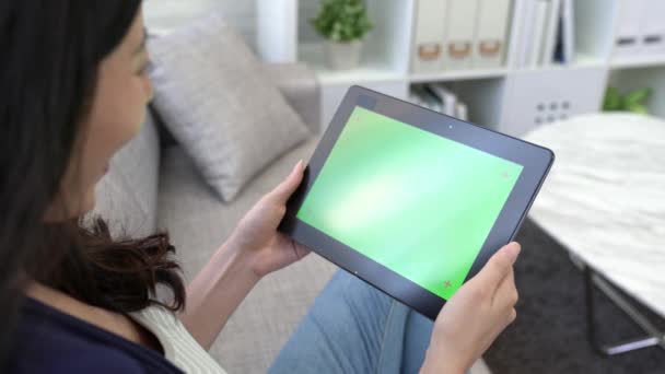 家庭での休暇中にオンラインの映画を見ながらソファに座っている女性に緑色の画面でモバイル デジタル タブレットを見て幸せな少女 — ストック動画