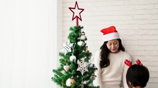 Merry Christmas Happy Holidays Asian Mom Daughter Decorate Christmas Tree — Stock Video