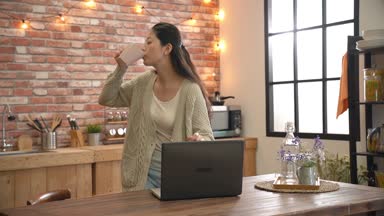 evinde müzik kadın Asya Dj bilgisayarın yavaş. Mutfak atmosferde yüksek ve büyük.