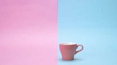 Renkli bardak kulplu masaya ortaya. Bir punchy pastel arka plan üzerinde.