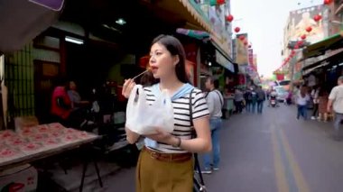 Changhua, Tayvan - 26 Mart 2018: Lukang eski sokakta yürürken ve yeme Asyalı kadın kızarmış tavuk.