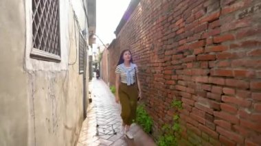 Asyalı kadın eğlence dar antik yerleşim bölgesinde sokak yürüyüşe.