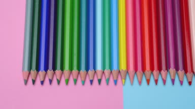 Renkli renkli kalemler düzgünce punchy pastel zemin üzerine koy. Bir yüksek açılı görünüş.