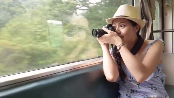 Молодая Азиатка Держит Камеру Фотографирует Природный Пейзаж Пределами Поезда — стоковое видео