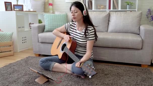 Aziatische Vrouwelijke Componist Haar Hoofd Knikken Tik Haar Gitaar Woonkamer — Stockvideo