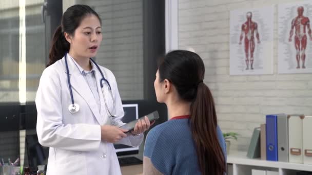 亚洲女性医生用数码片记录病人的情况 — 图库视频影像
