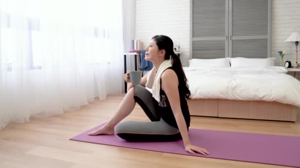 Asiatic Femeie Ședință Yoga Mat Bea Unele Ceai Fierbinte Folosind — Videoclip de stoc