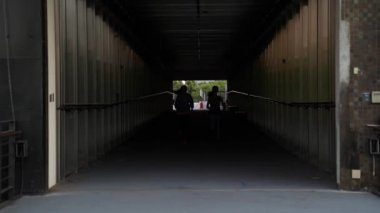 tünel üzerinden iki çalışan sporcuların ağır çekim. şehirde jogging arkadaş. çalışmasını kasıtlı son derece karanlık ışık renkleri.