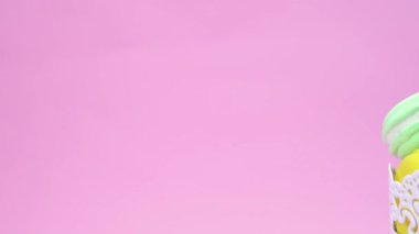 Altı macarons bir heal yığılmış ve bir kase yerleştirilir. Punchy pastel arka plan üzerinde dönen tutar.